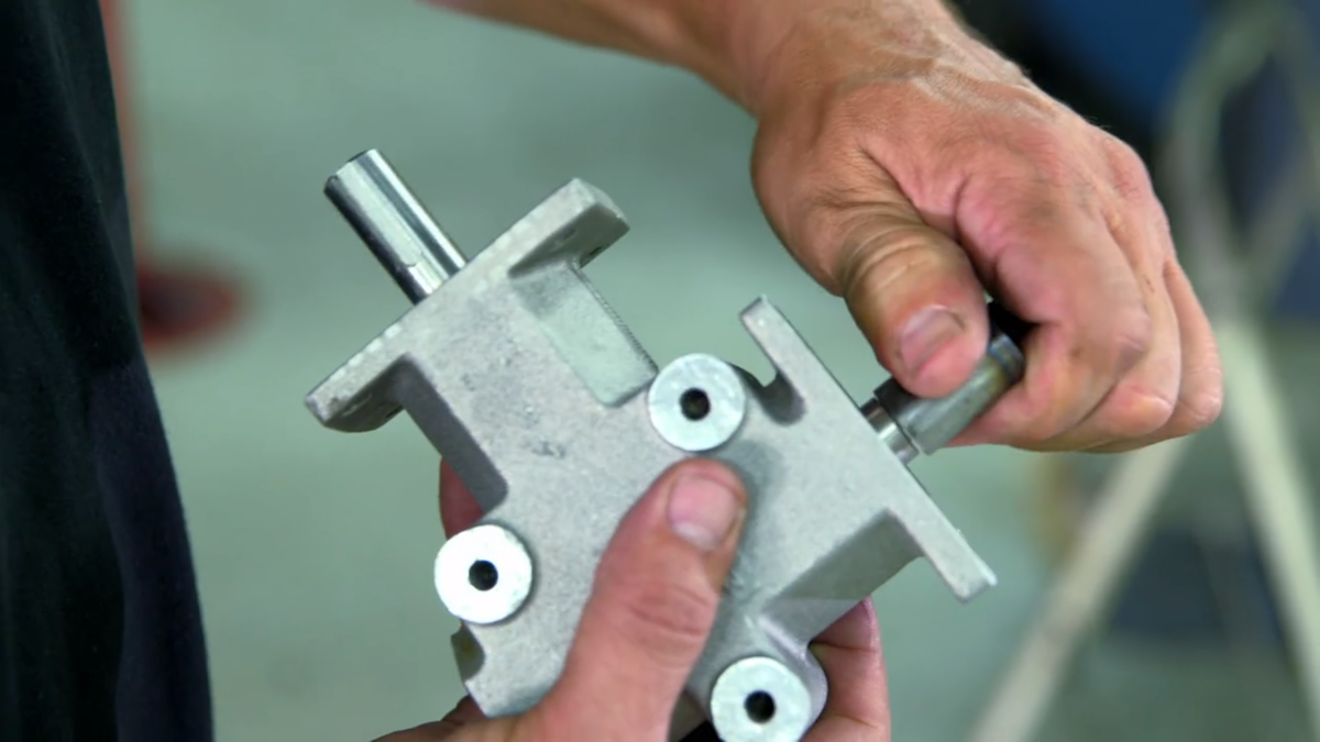 Two hands turning a shaft on a MITRPAK right angle gearbox 