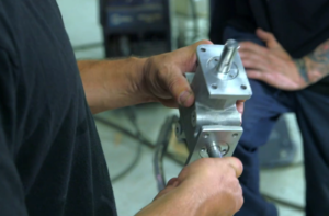 two hands holding a MITRPAK right angle spiral bevel gear drive