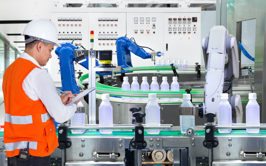 A techincian inspects machinery using right angle gear drives in a bottling plant
