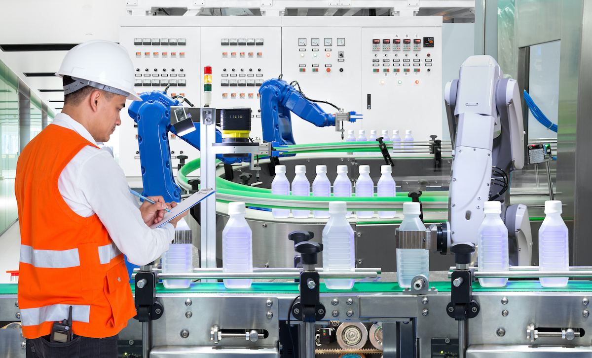 A techincian inspects machinery using right angle gear drives in a bottling plant