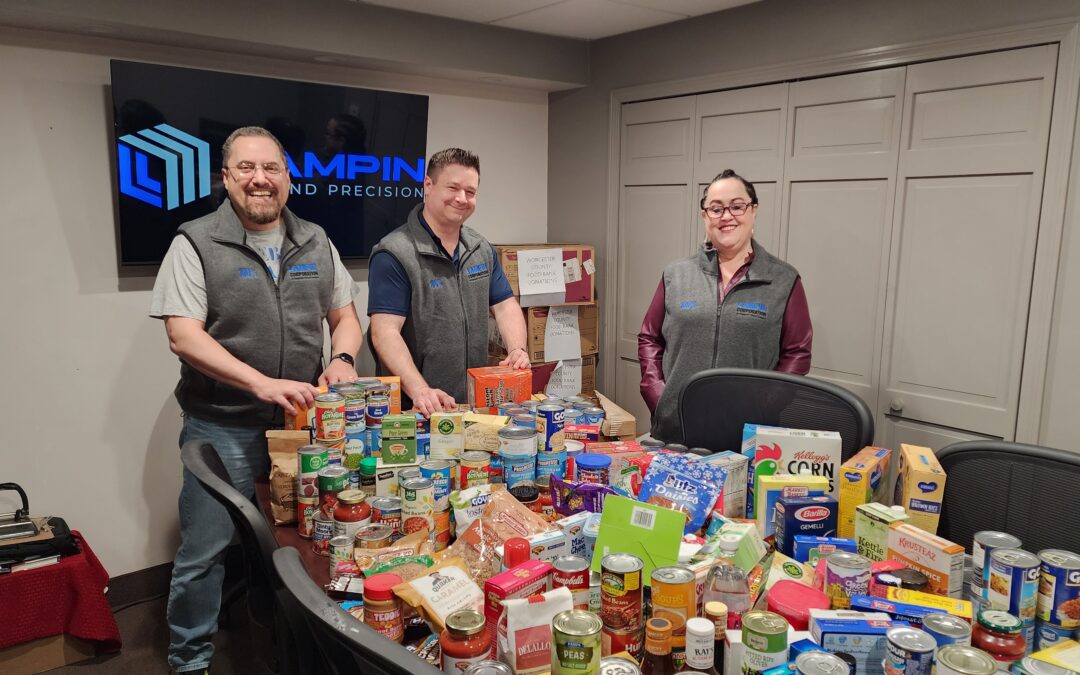 Lampin employee owners stand behind a table covered in food donations