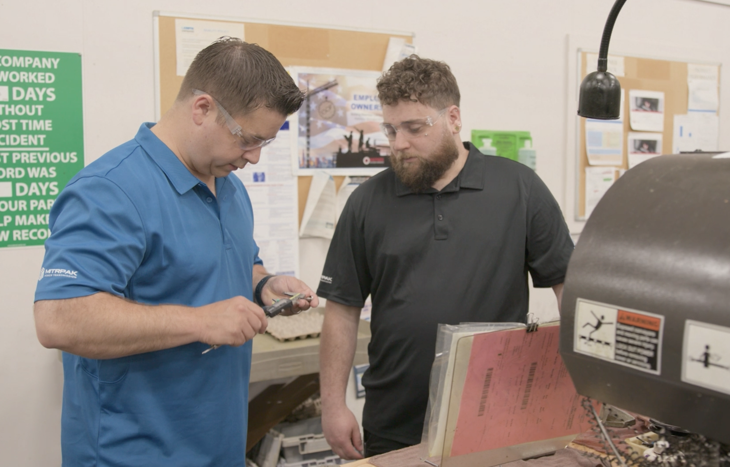 Director of Operations Keith mentoring employee-owner Mike on the shop floor, illustrating the one-on-one technical support and leadership culture at Lampin.