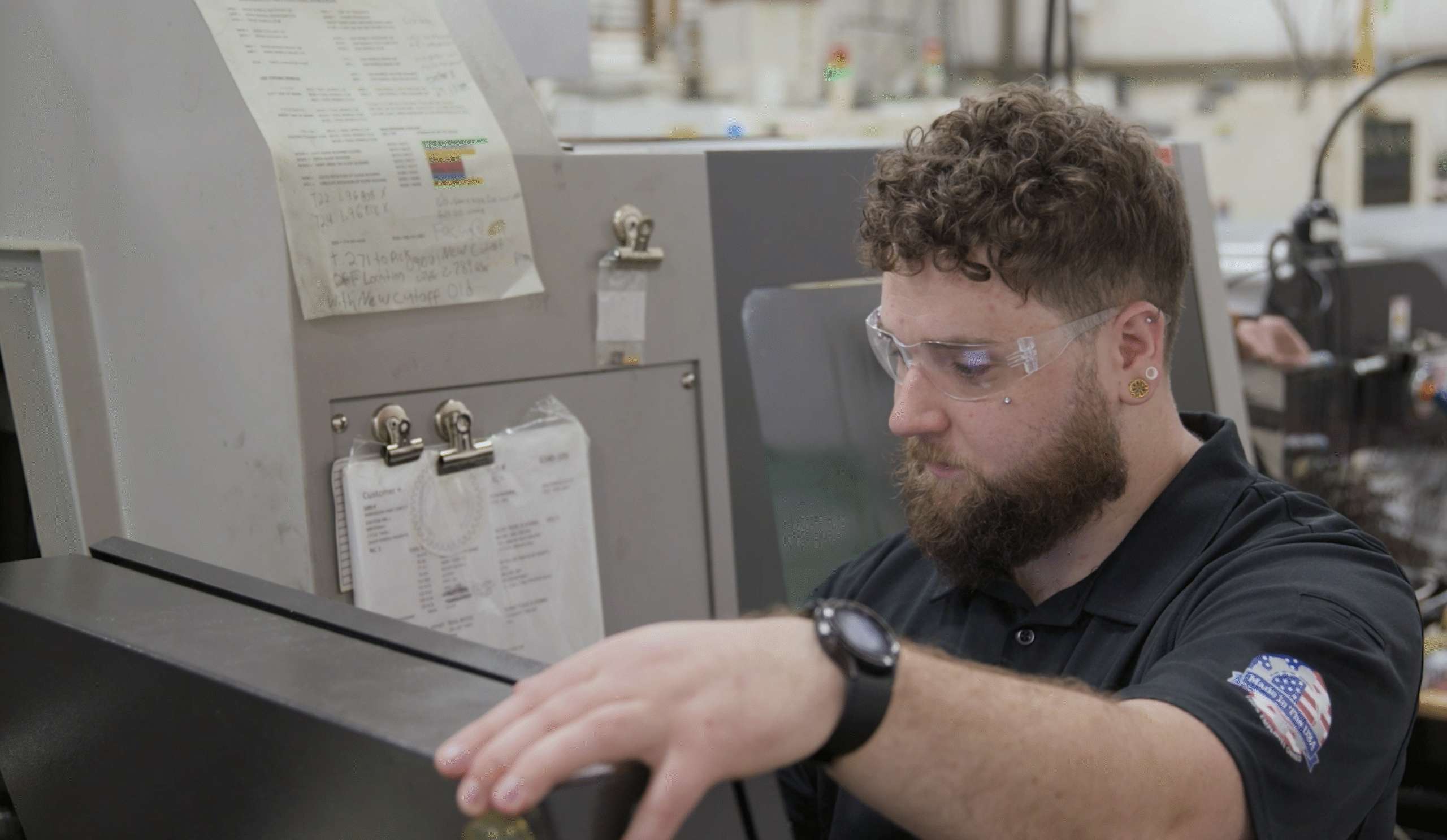 Employee-owner Mike operating a high-precision CNC control panel at Lampin, focused on programming a complex manufacturing setup.